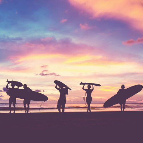 Silhouettes de surf au soleil couchant